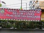 Spanduk di Hotel Syariah Grand Jamee "Tanah dan Bangunan Ini Belum Lunas Pajak Bumi Bangunan"