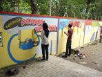 Seniman 'Coret-coret' Tembok Pagar Kantor Camat Medan Helvetia